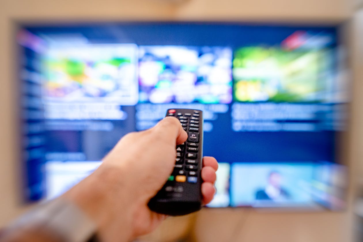 apollo group tv pricing - hand holding remote with streaming interface